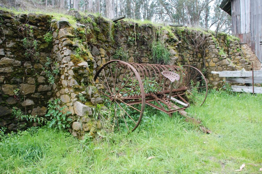 Rusting farm implements are scattered throughout the site
